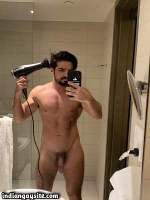 Muscled nude hunk shows off big dick in the mirror
