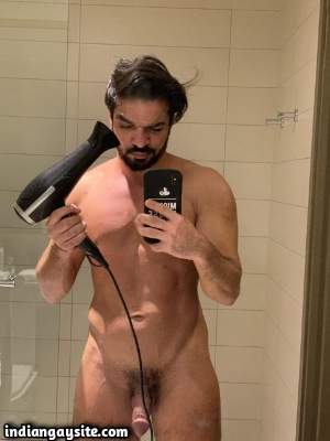 Muscled nude hunk shows off big dick in the mirror